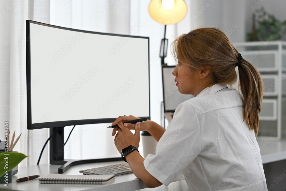 Poster focused developer analyzing information on wide screen monitor