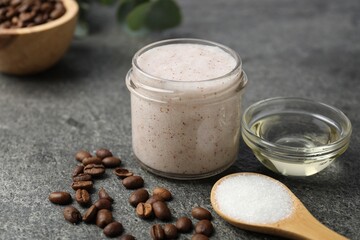 Natural body scrub in glass jar and ingredients on grey table, closeup