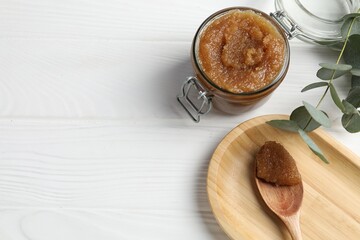 Natural body scrub and eucalyptus branches on white wooden table, flat lay. Space for text