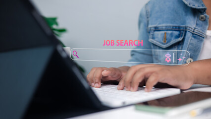 Person searching for jobs online using a computer with digital JOB SEARCH text overlay,...