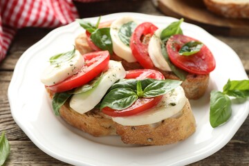 Delicious sandwiches with mozzarella cheese, tomatoes and basil on wooden table, closeup