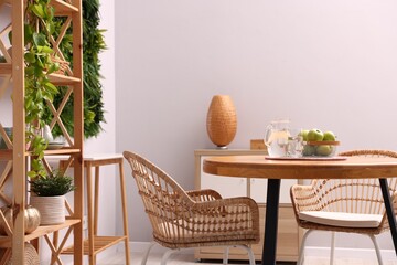 Wooden table with chairs and decor in stylish dining room. Interior design