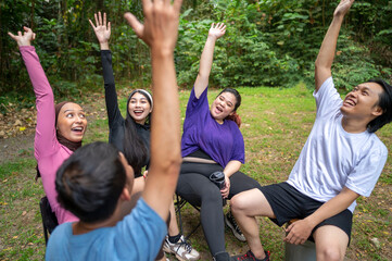 Indonesian southeast asian people in a sporty outfit, stacking hands together before practice...