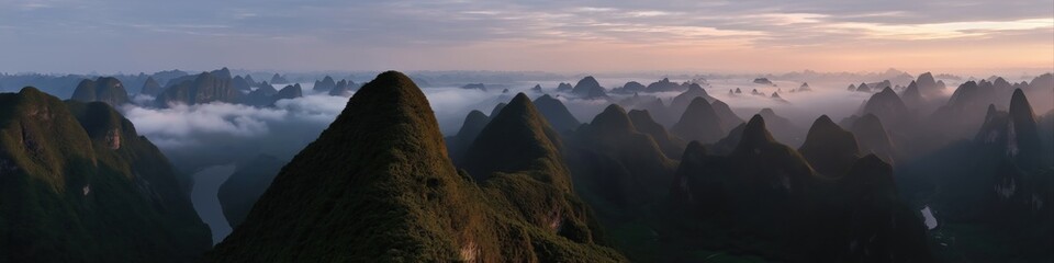 Obraz premium Majestic mountains with mist at sunrise: serene landscape and river view