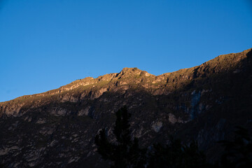 Sonnenlicht auf den Bergspitzen im Colca Canyon in Peru bei blauem Himmel