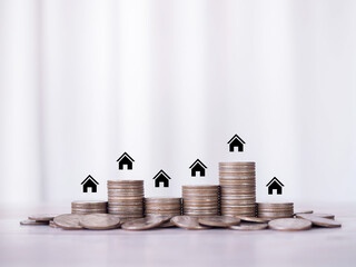 Miniature house icons and stack of coins. The concept of saving money for house, Property...