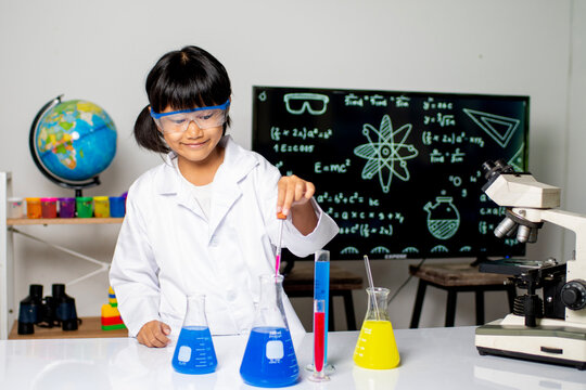 Budding Scientist's Laboratory Exploration: A curious young student in a lab coat and goggles experiments with colorful liquids in beakers.