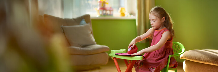 Girl Playing with Toy Ironing Set in Wide Banner