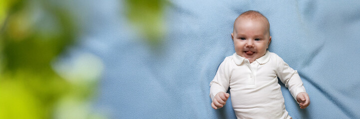 Smiling Baby Lying on Blue Blanket Wide Banner