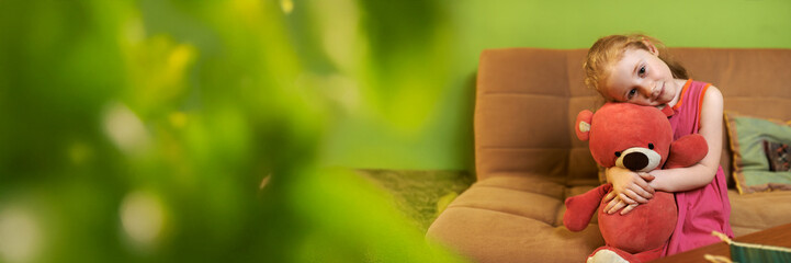 Girl with Teddy Bear on Sofa Wide Banner