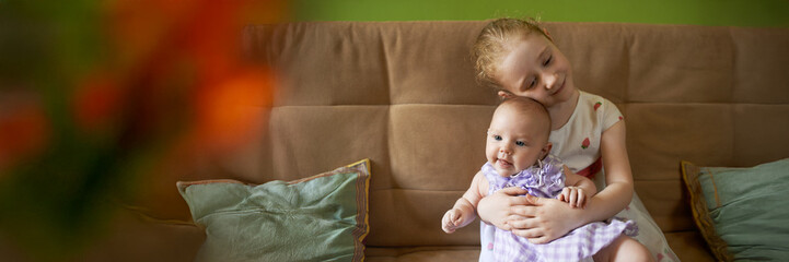 Sisterly Affection on Sofa Wide Banner