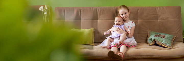 Girls Sitting on Couch with Copy Space Wide Banner