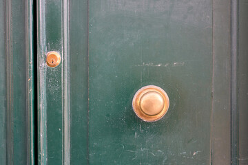 Green door featuring golden handle and keyhole
