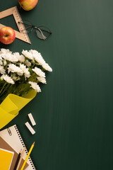 Elegant vertical teacher's day image featuring objects on a green chalkboard. Items include chalk,...