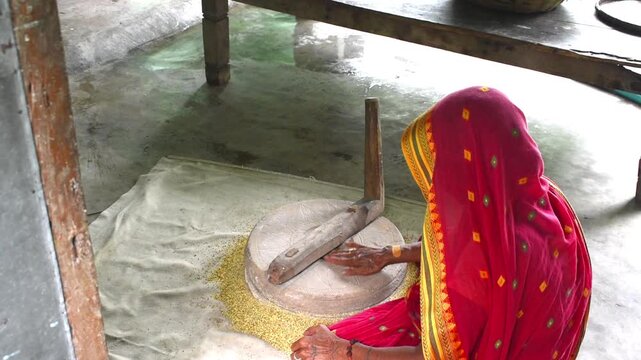 Rural lifestyle and traditional food preparation in Indian villages where lady using Stone Jata or hand chakki at home.