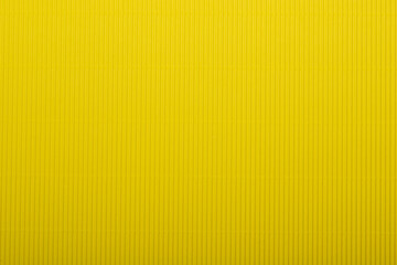 A vibrant yellow corrugated surface with a ribbed texture, perfect for use as an abstract...