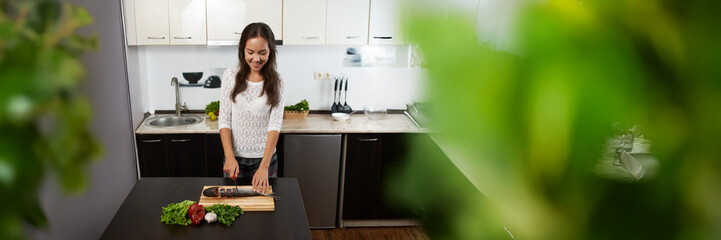 Happy Woman Cooking in Modern Kitchen Wide Banner