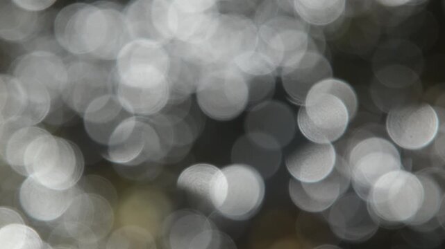 Hektisches sich schnell bewegendes abstraktes unscharfes Video mit runden wei&szlig;en Licht Reflektionen vor einem dunklen Hintergrund