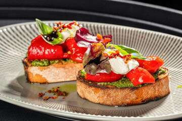 Bruschetta with roasted red peppers, pesto, fresh basil, mixed greens, and creamy ricotta cheese, served on toasted rustic bread with a drizzle of balsamic glaze