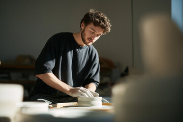 Young Artist Sculpting Clay on Pottery Wheel