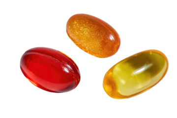 Three translucent oval capsules in varying shades of orange, red, and yellow, positioned in a loose group against a black background.  Each capsule displays a subtle, speckled texture