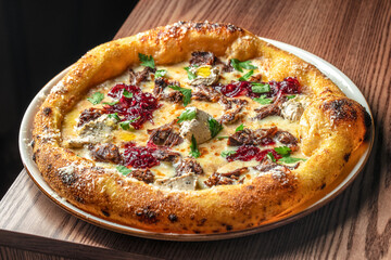 Gourmet pizza topped with slow-cooked beef, caramelized onions, herbs, and melted cheese on a...