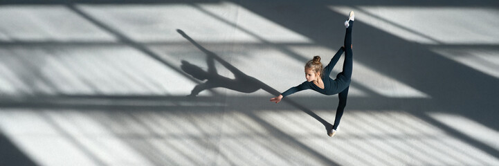 Young Gymnast Performing Split on Wide Banner with Copy Space