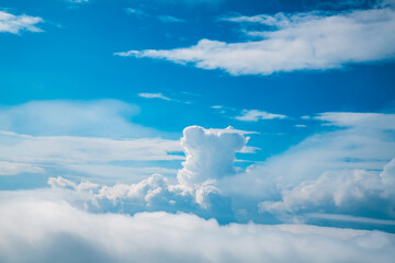 Beautiful white cumulus clouds forming against a bright blue sky on a sunny day, creating a...