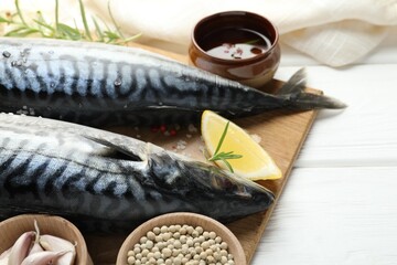 Seafood delicacies. Fresh raw mackerels and spices on white wooden table, closeup. Space for text