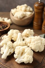 Fresh raw cauliflower florets and spices on table, closeup