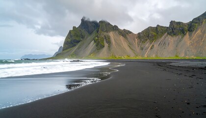 Dramatic Black Sand Beach with Jagged Peaks and Misty Clouds in Iceland