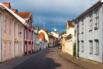 Historic buildings in mixed colors and shapes along the paving-covered Storgatan in Vimmerby, Sweden