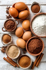 Baking ingredients flat lay on white wood table top down view eggs flour cocoa cinnamon sugar anise