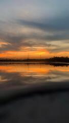 A serene sunset over calm water with golden and orange hues