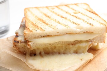 Tasty sandwich with melted cheese on table, closeup