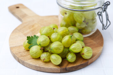 Fresh green gooseberries on white table, closeup