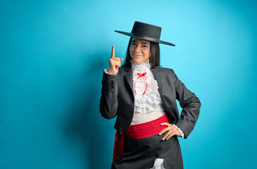 Young woman wearing a traditional chilean huasa clothing pointing up with her finger, National...