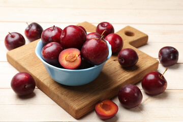 Ripe cherry plums on light wooden table, closeup