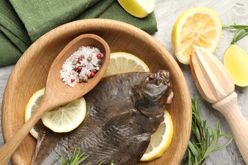 Fresh raw flounder fish, spices and wooden juicer on grey table, flat lay. Seafood