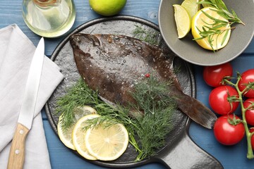 Fresh raw flounder fish, ingredients and knife on blue wooden table, flat lay. Seafood