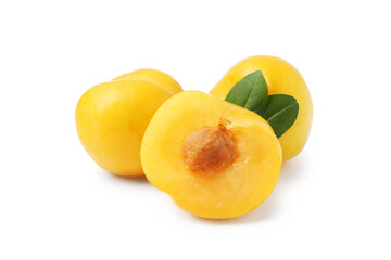 Whole and cut yellow cherry plums with leaves isolated on white