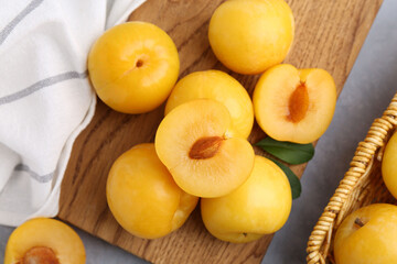 Ripe yellow cherry plums on grey table, flat lay
