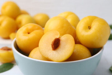 Ripe yellow cherry plums on white tiled table, closeup