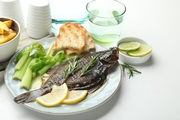 Tasty roasted flounder fish with celery served on white table, closeup. Homemade seafood dish