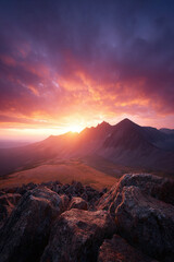 Naklejka premium Majestic mountain range at sunset. Vibrant sky with shades of red and purple. Inspiring landscape. Ideal for travel, adventure, or aspirational concepts.