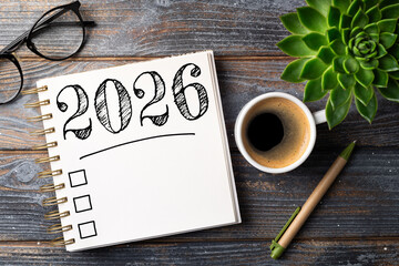New year resolutions 2026 on desk. 2026 resolutions list with notebook, coffee cup on table. Goals,...