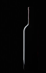 Red wine bottle silhouette over black background.