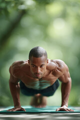 Focused portrait of a strong man in a pushup position outdoors, symbolizing fitness, determination, and healthy lifestyle. Ideal for sports, wellness, and health content.