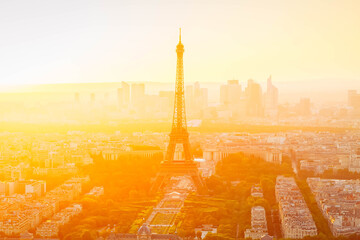 view of Eiffel Tower and Paris cityscape from above in orange sunset sunlight, France