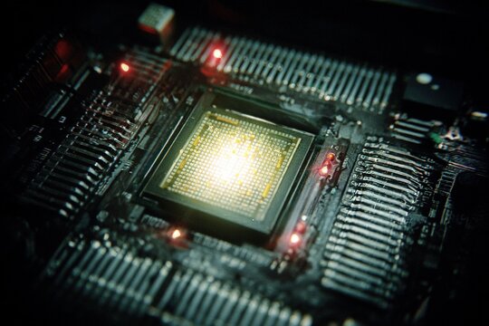 Close-up view of a microprocessor circuit board with glowing lights during an electronics project at a tech workshop